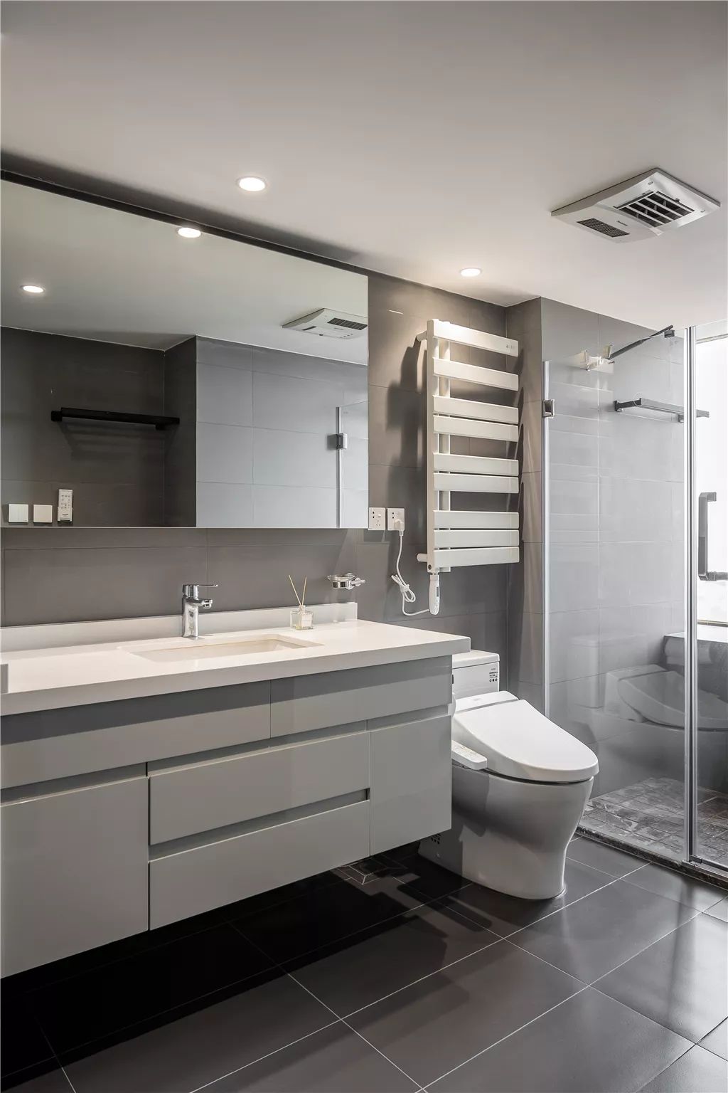 20▲卫生间整体简约灰色的空间，结合白色洗手盆柜、马桶与毛巾架，提供了一种现代素雅的卫浴空间感。.jpg