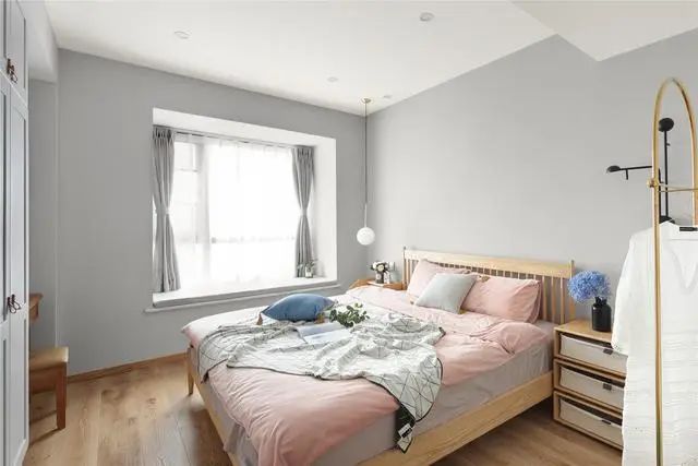 4主卧设计的十分简单，墙壁直接刷成了高级灰色的格调，搭配浅色的实木地板装饰，使得卧室显得非常时尚有档次感，让生活更加惬意舒适。浅色的实木大床非常精致宽敞，搭配舒适的被褥，营造出一种温馨舒适的休息环境。.jpg