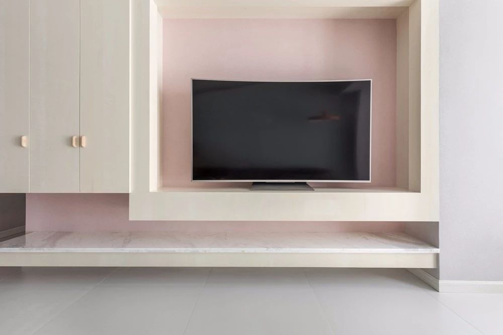 2定制柜为电视墙的设计，电视柜加入了大理石台面，而背景则是淡粉色的布置，营造出一种浪漫温情的视觉感。.jpg