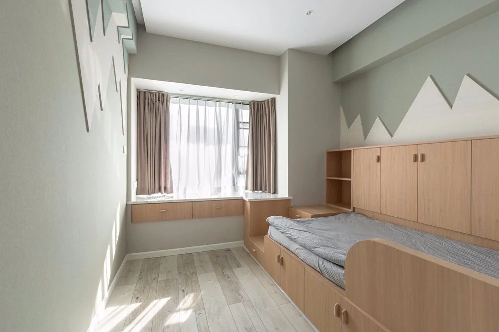 9儿童房以淡绿色的墙面基础，定制上木质的榻榻米床+收纳柜组合，墙面上加入小山造型的设计，让儿童房空间实用童趣两不误。.jpg